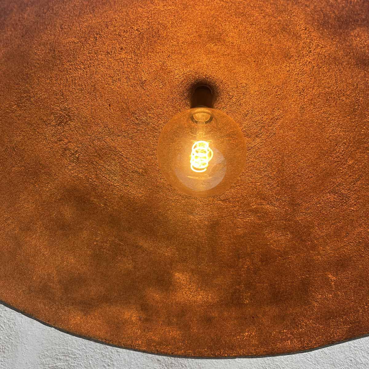 Vista di profilo della lampada scultorea Moki in cemento